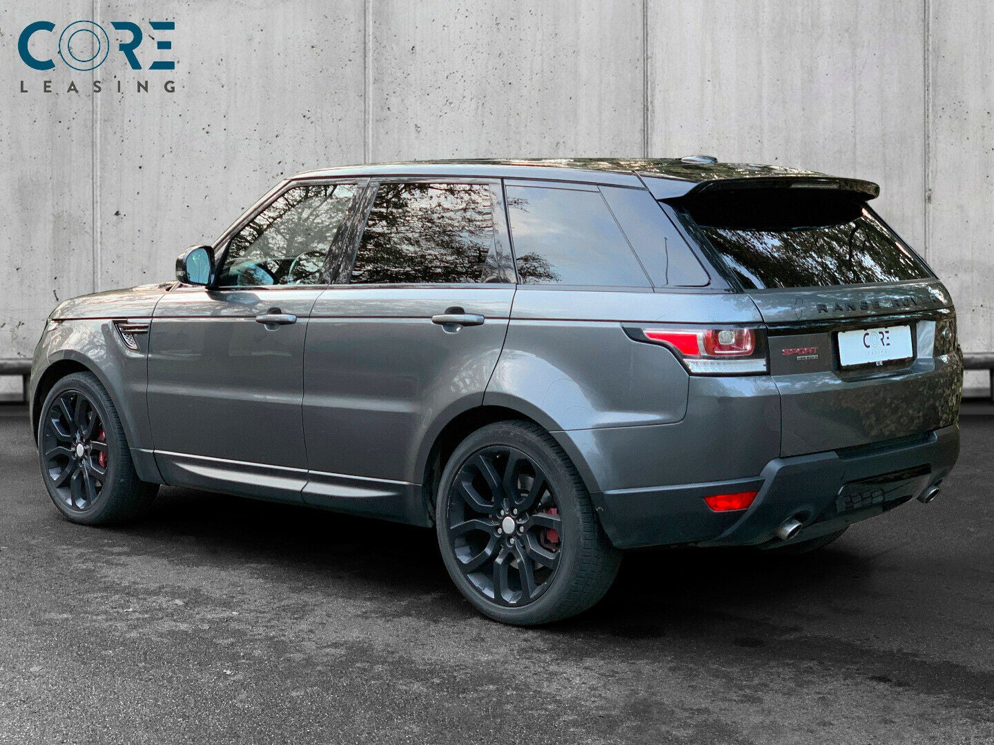 Gråmetal Land Rover Range Rover Sport SDV6 HSE aut. fra 2013 parkeret foran en betonmur. CORE Leasing A/S er eksperter i Land Rover leasing.