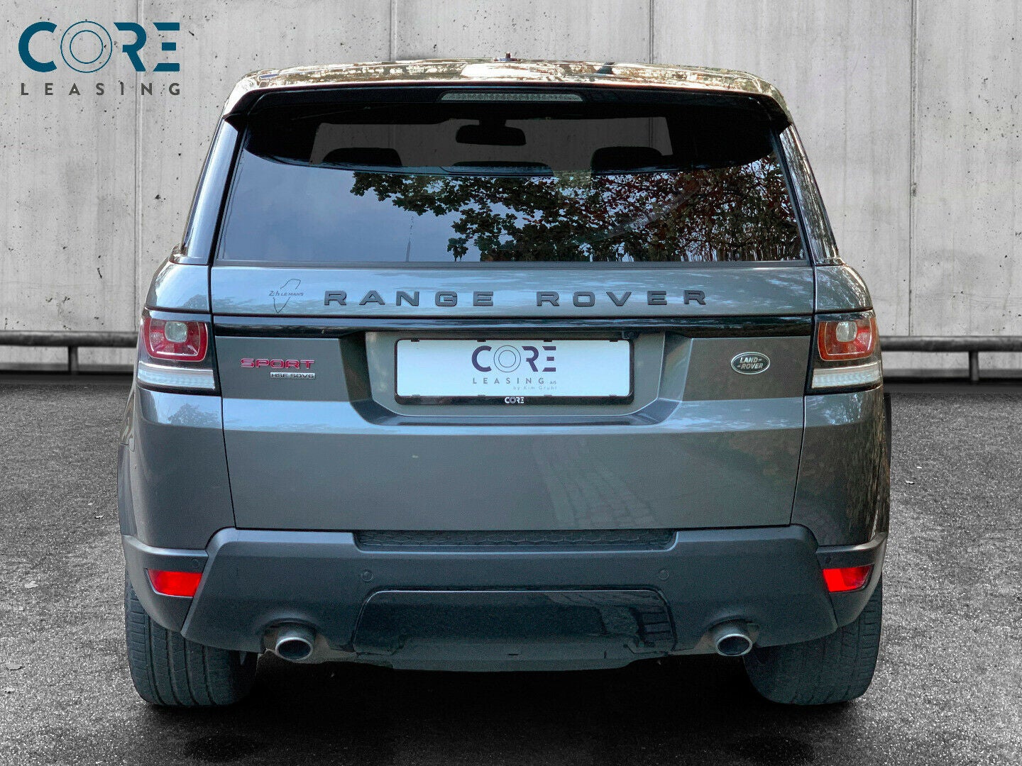 Gråmetal Land Rover Range Rover Sport SDV6 HSE aut. fra 2013 parkeret foran en betonmur. CORE Leasing A/S er eksperter i Land Rover leasing.