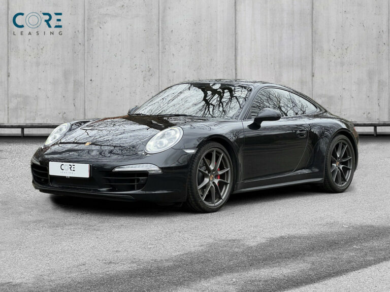 Sortmetal Porsche 911 Carrera 4S Coupé PDK fra 2013 parkeret foran en betonmur. CORE Leasing A/S er eksperter i Porsche leasing.
