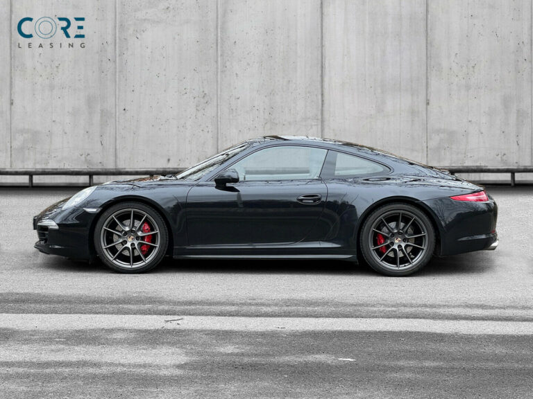 Sortmetal Porsche 911 Carrera 4S Coupé PDK fra 2013 parkeret foran en betonmur. CORE Leasing A/S er eksperter i Porsche leasing.