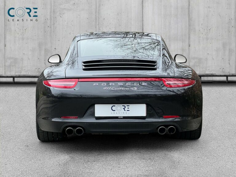 Sortmetal Porsche 911 Carrera 4S Coupé PDK fra 2013 parkeret foran en betonmur. CORE Leasing A/S er eksperter i Porsche leasing.