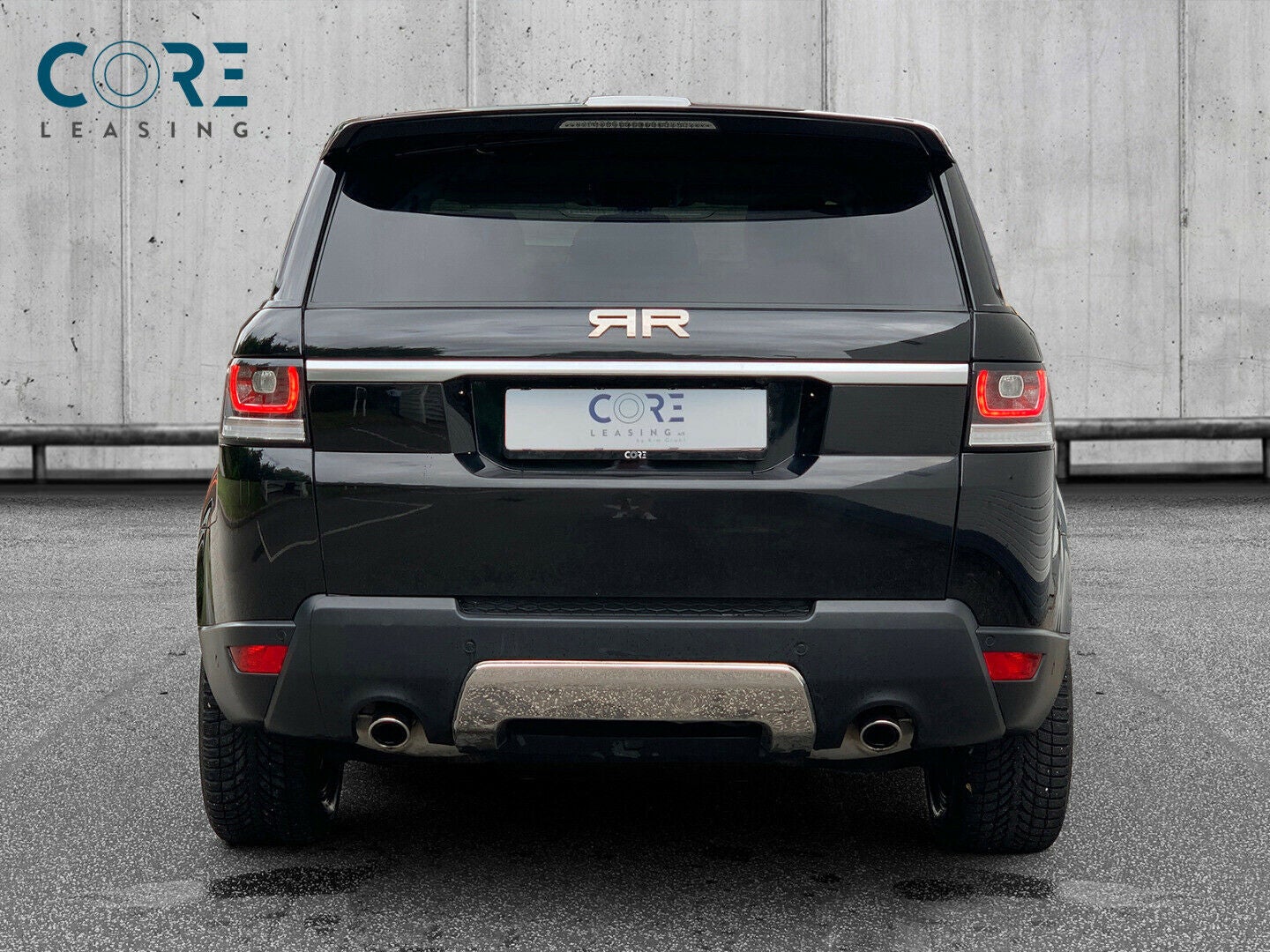 Sortmetal Land Rover Range Rover Sport TDV6 HSE aut. fra 2015 parkeret foran en betonmur. CORE Leasing A/S er eksperter i Land Rover leasing.