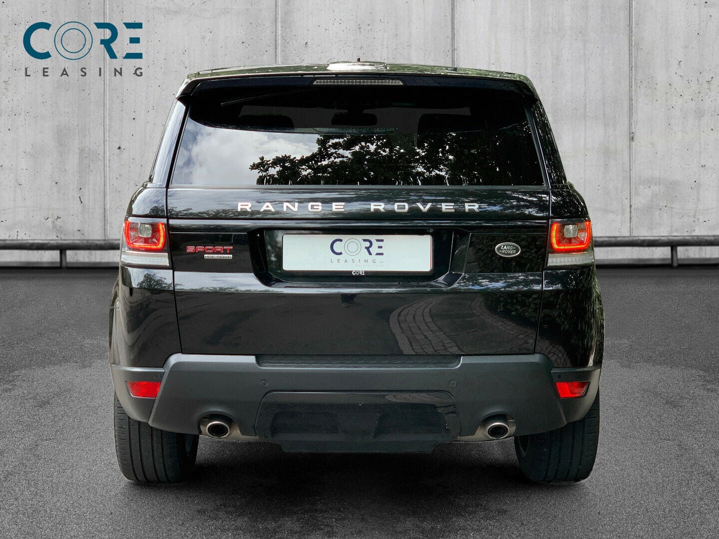 Sortmetal Land Rover Range Rover Sport SDV6 HSE aut. fra 2015 parkeret foran en betonmur. CORE Leasing A/S er eksperter i Land Rover leasing.