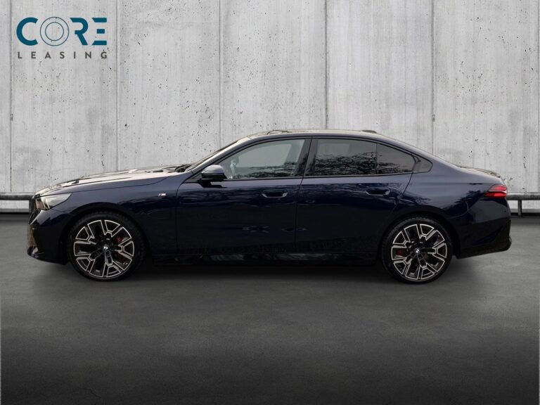 Blåmetal BMW 550e M-Sport xDrive aut. fra 2024 parkeret foran en betonmur. CORE Leasing A/S er eksperter i BMW leasing.