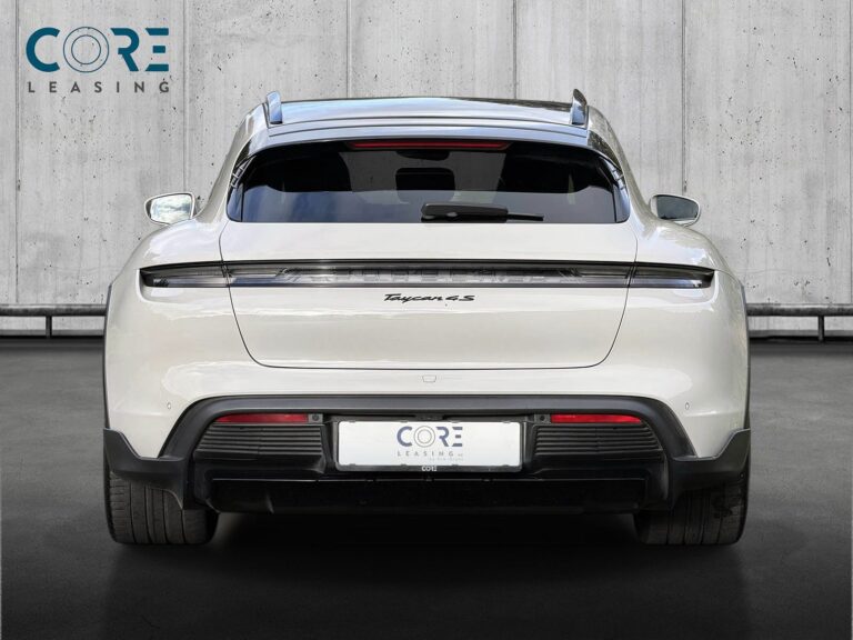 Grå Porsche Taycan 4S Sport Turismo fra 2022 parkeret foran en betonmur. CORE Leasing A/S er eksperter i Porsche leasing.