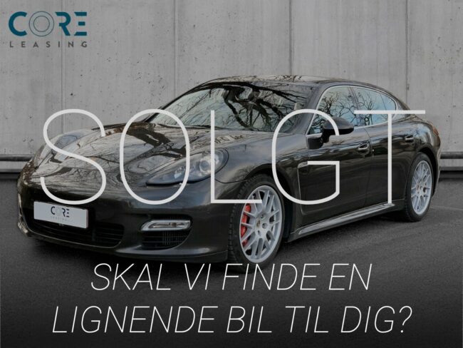 Gråmetal Porsche Panamera Turbo S PDK fra 2011 parkeret foran en betonmur. CORE Leasing A/S er eksperter i Porsche leasing.