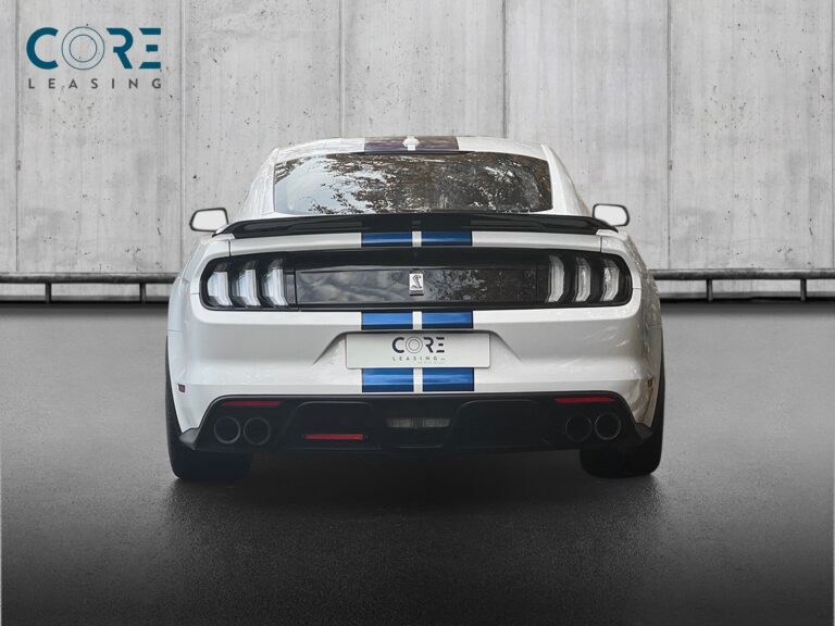 Hvid Ford Mustang Shelby GT350 Coupé fra 2017 parkeret foran en betonmur. CORE Leasing A/S er eksperter i Ford leasing.