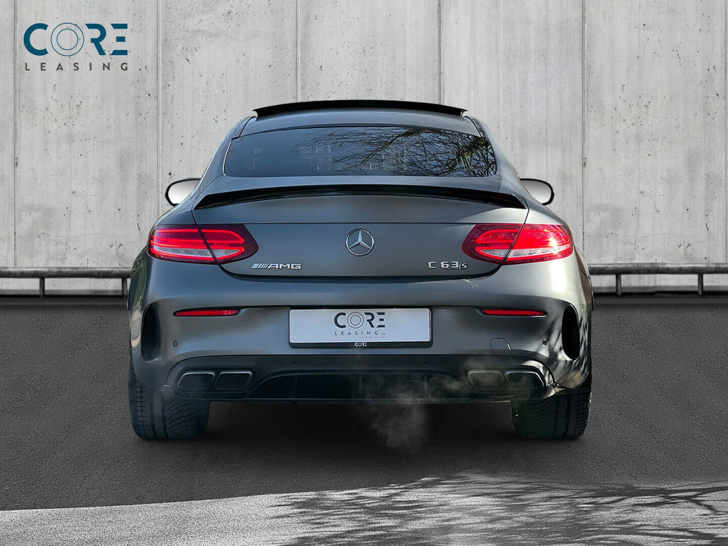 Gråmetal Mercedes C63 AMG S Coupé aut. fra 2016 parkeret foran en betonmur. CORE Leasing A/S er eksperter i Mercedes leasing.