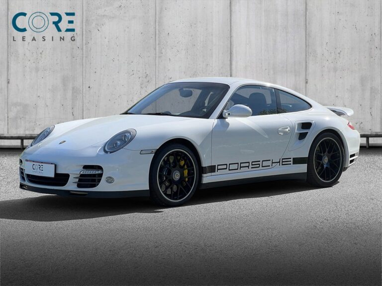 Hvidmetal Porsche 911 Turbo Coupé PDK fra 2011 parkeret foran en betonmur. CORE Leasing A/S er eksperter i Porsche leasing.