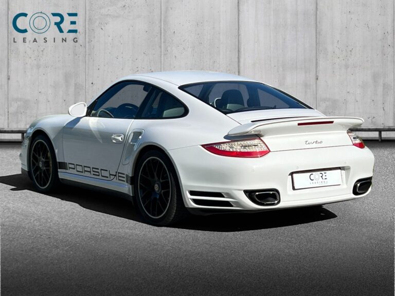 Hvidmetal Porsche 911 Turbo Coupé PDK fra 2011 parkeret foran en betonmur. CORE Leasing A/S er eksperter i Porsche leasing.