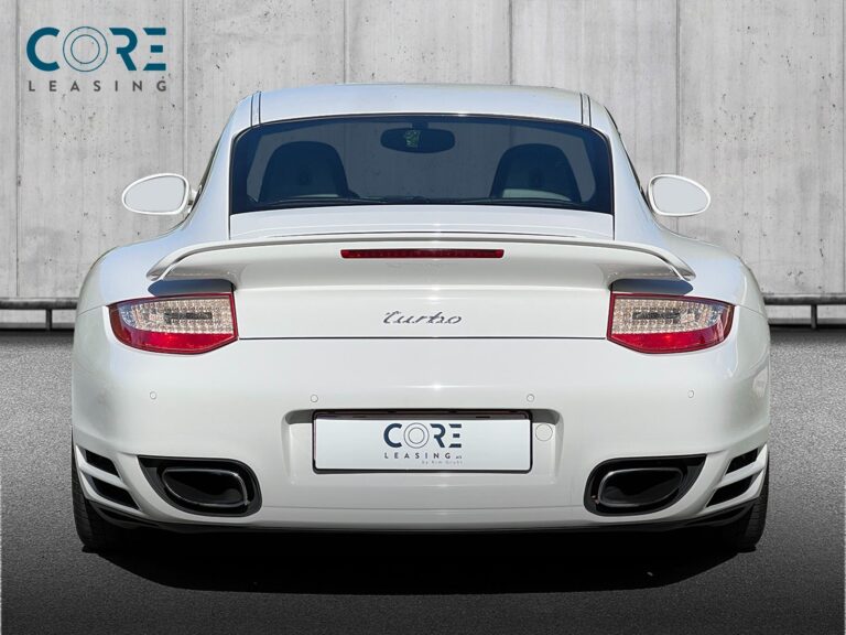 Hvidmetal Porsche 911 Turbo Coupé PDK fra 2011 parkeret foran en betonmur. CORE Leasing A/S er eksperter i Porsche leasing.