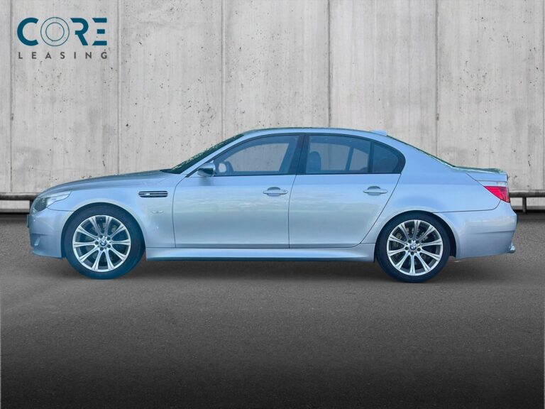 Sølvmetal BMW M5 SMG fra 2005 parkeret foran en betonmur. CORE Leasing A/S er eksperter i BMW leasing.