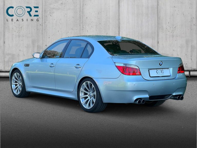 Sølvmetal BMW M5 SMG fra 2005 parkeret foran en betonmur. CORE Leasing A/S er eksperter i BMW leasing.