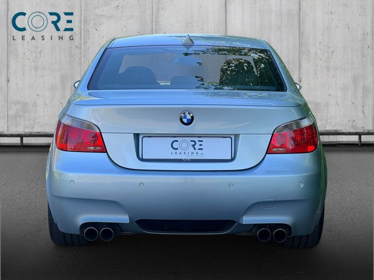 Sølvmetal BMW M5 SMG fra 2005 parkeret foran en betonmur. CORE Leasing A/S er eksperter i BMW leasing.