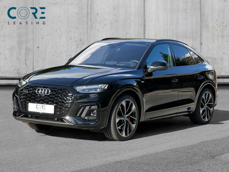 Sortmetal Audi Q5 TFSi e S-line Sportback quattro S-tr. fra 2021 parkeret foran en betonmur. CORE Leasing A/S er eksperter i Audi leasing.