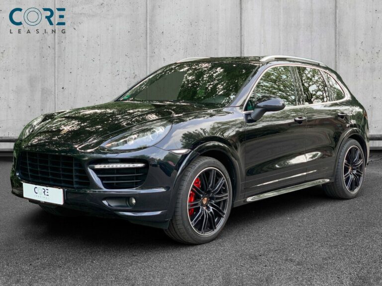 Sortmetal Porsche Cayenne GTS Tiptr. fra 2013 parkeret foran en betonmur. CORE Leasing A/S er eksperter i Porsche leasing.