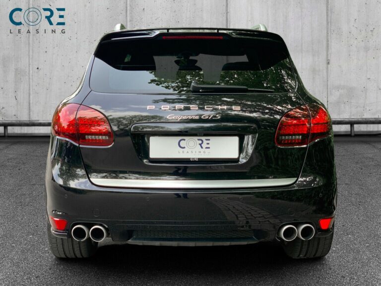 Sortmetal Porsche Cayenne GTS Tiptr. fra 2013 parkeret foran en betonmur. CORE Leasing A/S er eksperter i Porsche leasing.