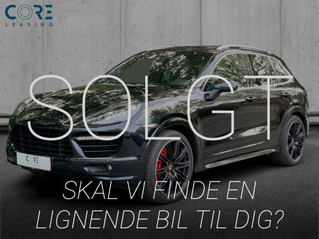 Sortmetal Porsche Cayenne GTS Tiptr. fra 2013 parkeret foran en betonmur. CORE Leasing A/S er eksperter i Porsche leasing.