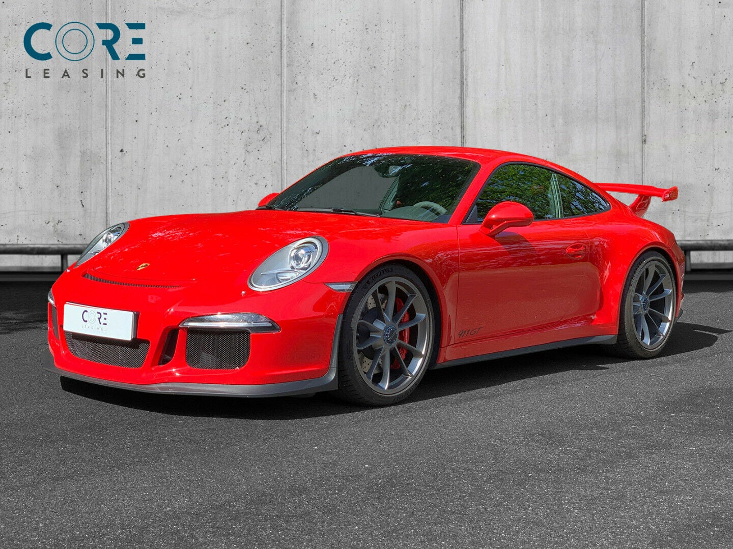 Rød Porsche 911 GT3 Coupé PDK fra 2014 parkeret foran en betonmur. CORE Leasing A/S er eksperter i Porsche leasing.
