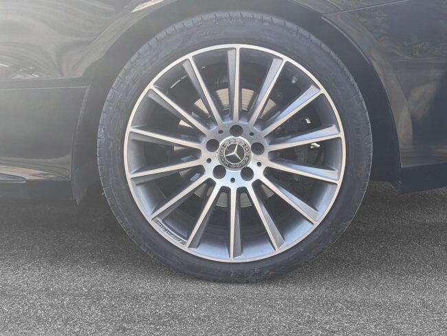 Sortmetal Mercedes C400 AMG Line Cabriolet aut. 4Matic fra 2018 parkeret foran en betonmur. CORE Leasing A/S er eksperter i Mercedes leasing.