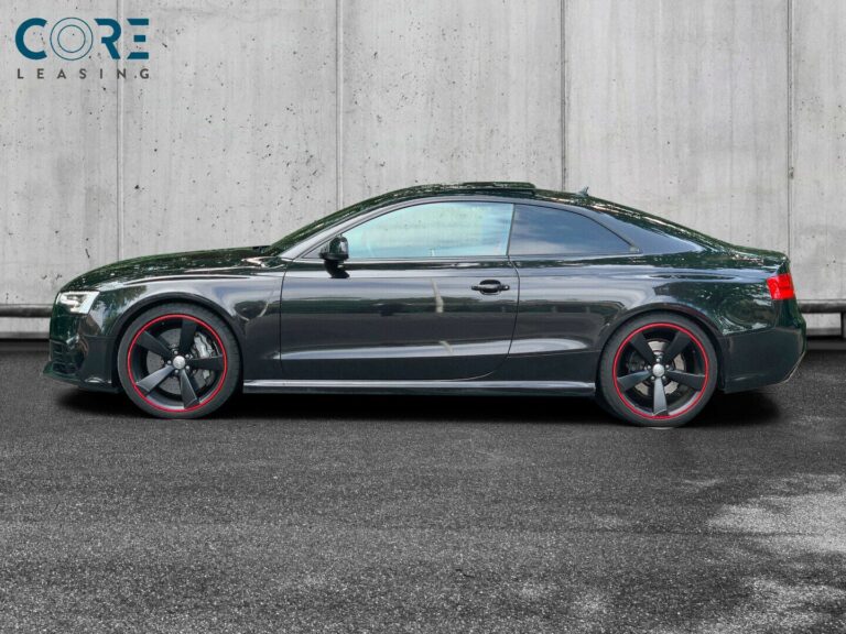 Audi RS5 FSi Coupé quattro S-tr. fra 2014 parkeret foran en betonmur. CORE Leasing A/S er eksperter i Audi leasing.