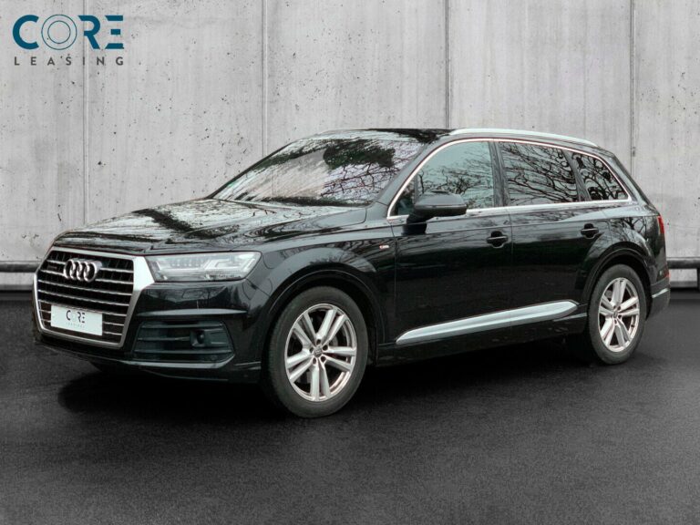 Sortmetal Audi Q7 TDi 272 S-line quattro Tiptr. 7prs fra 2015 parkeret foran en betonmur. CORE Leasing A/S er eksperter i Audi leasing.