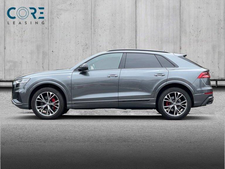 Gråmetal Audi Q8 TDi S-line quattro Tiptr. fra 2019 parkeret foran en betonmur. CORE Leasing A/S er eksperter i Audi leasing.