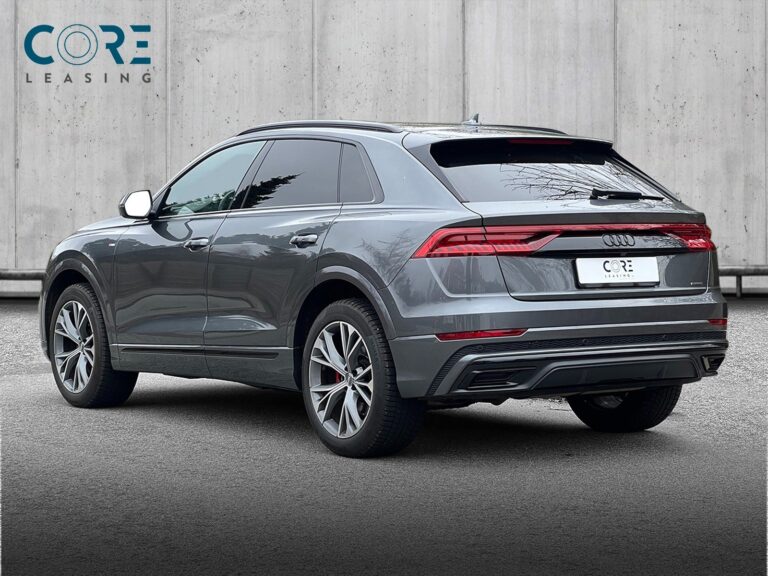 Gråmetal Audi Q8 TDi S-line quattro Tiptr. fra 2019 parkeret foran en betonmur. CORE Leasing A/S er eksperter i Audi leasing.