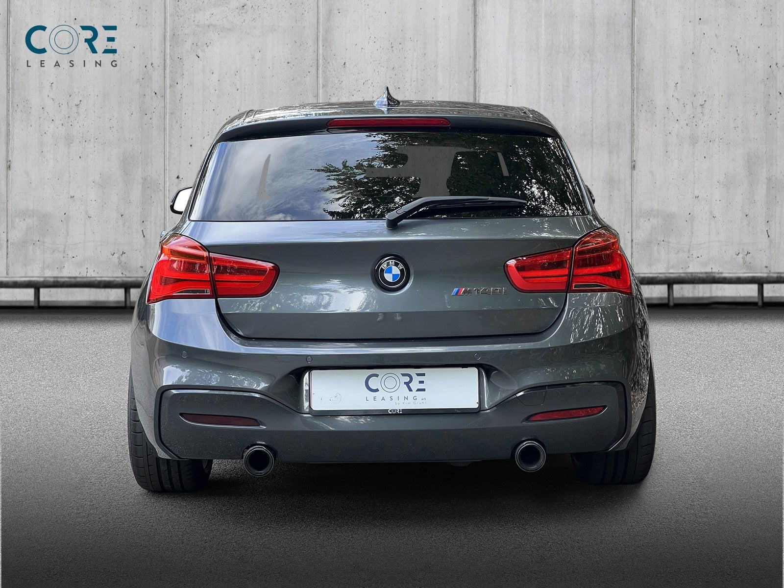 Gråmetal BMW M140i xDrive aut. fra 2017 parkeret foran en betonmur. CORE Leasing A/S er eksperter i BMW leasing.