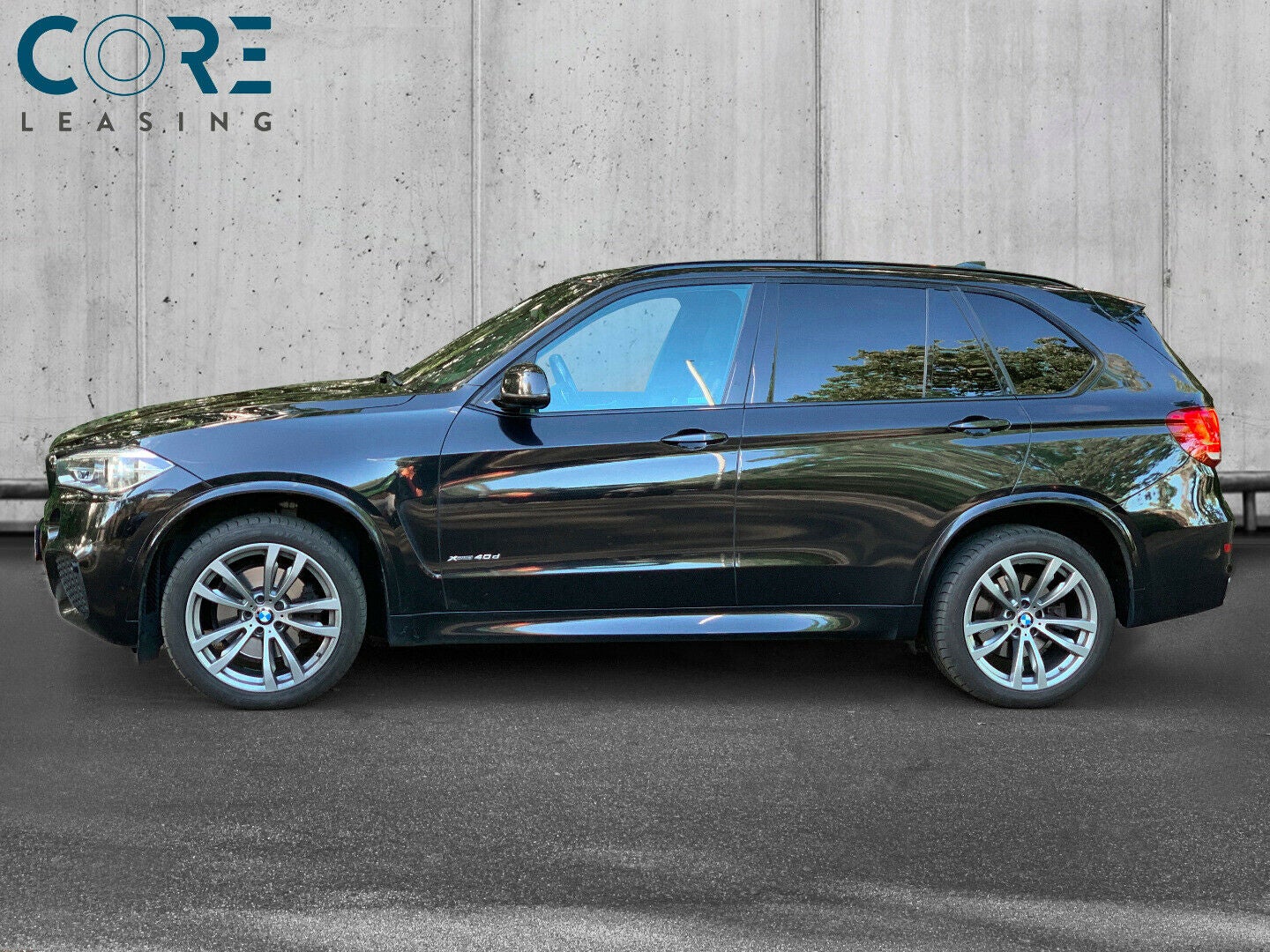 Sortmetal BMW X5 xDrive40d M-Sport aut. 7prs fra 2016 parkeret foran en betonmur. CORE Leasing A/S er eksperter i BMW leasing.