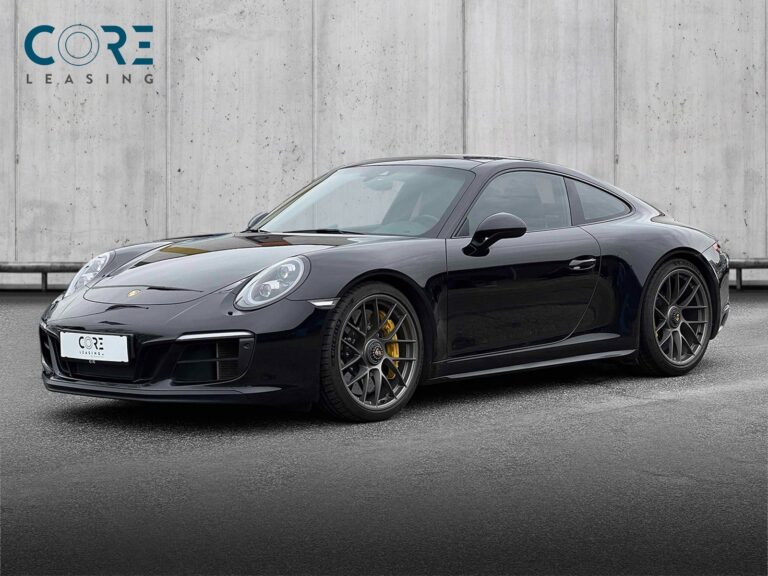 Sortmetal Porsche 911 Carrera 4 GTS Coupé PDK fra 2017 parkeret foran en betonmur. CORE Leasing A/S er eksperter i Porsche leasing.