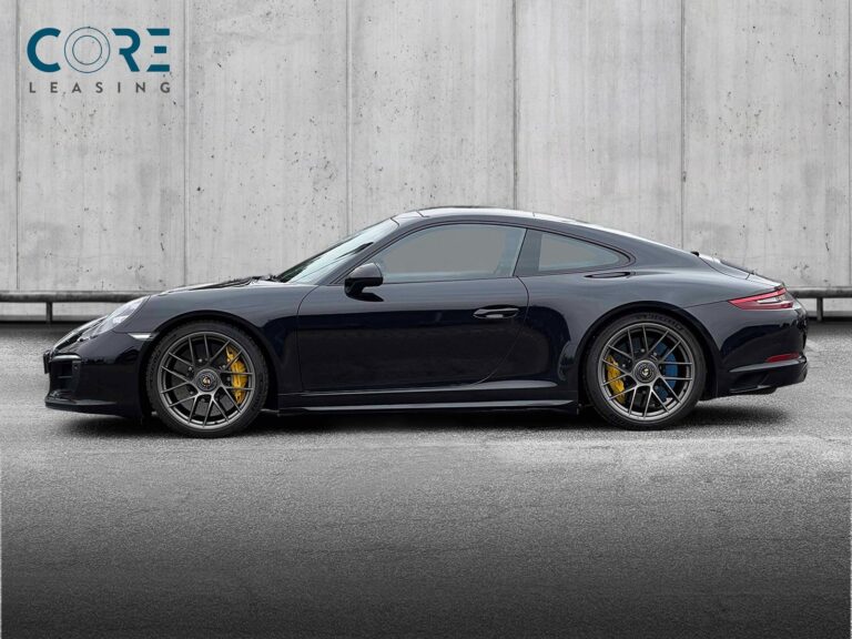 Sortmetal Porsche 911 Carrera 4 GTS Coupé PDK fra 2017 parkeret foran en betonmur. CORE Leasing A/S er eksperter i Porsche leasing.