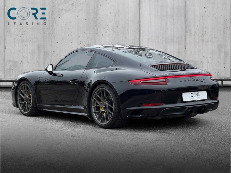 Sortmetal Porsche 911 Carrera 4 GTS Coupé PDK fra 2017 parkeret foran en betonmur. CORE Leasing A/S er eksperter i Porsche leasing.