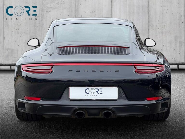 Sortmetal Porsche 911 Carrera 4 GTS Coupé PDK fra 2017 parkeret foran en betonmur. CORE Leasing A/S er eksperter i Porsche leasing.