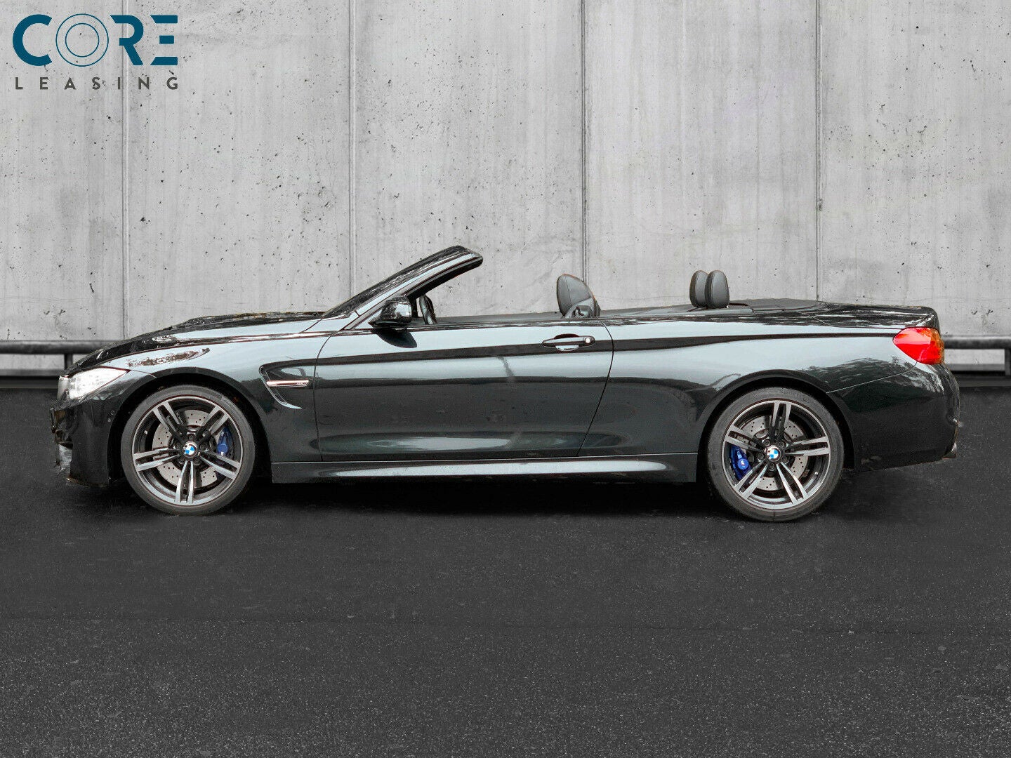 Sortmetal BMW M4 Cabriolet aut. fra 2016 parkeret foran en betonmur. CORE Leasing A/S er eksperter i BMW leasing.