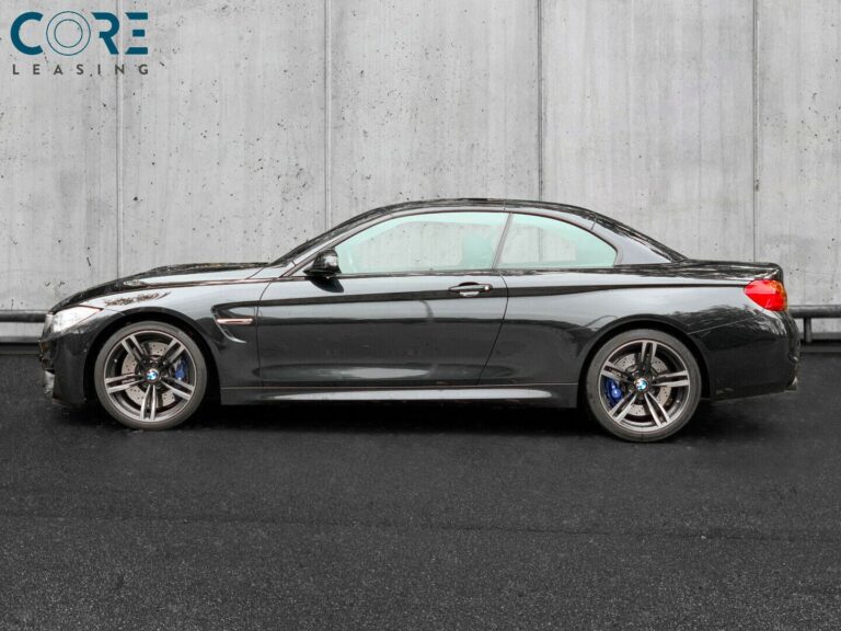 Sortmetal BMW M4 Cabriolet aut. fra 2016 parkeret foran en betonmur. CORE Leasing A/S er eksperter i BMW leasing.