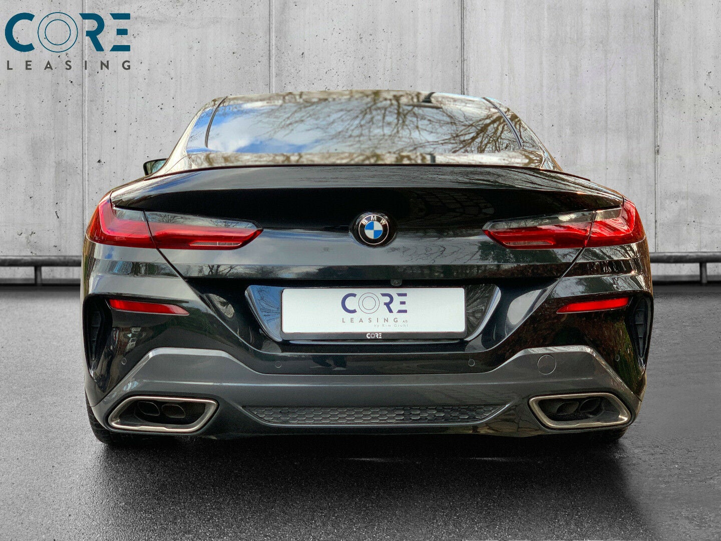Sortmetal BMW M850i Coupé xDrive aut. fra 2018 parkeret foran en betonmur. CORE Leasing A/S er eksperter i BMW leasing.