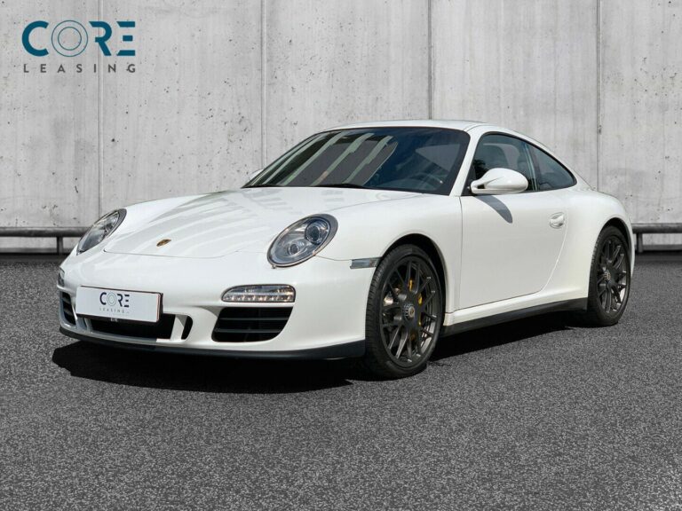Hvidmetal Porsche 911 Carrera 4 GTS Coupé fra 2012 parkeret foran en betonmur. CORE Leasing A/S er eksperter i Porsche leasing.