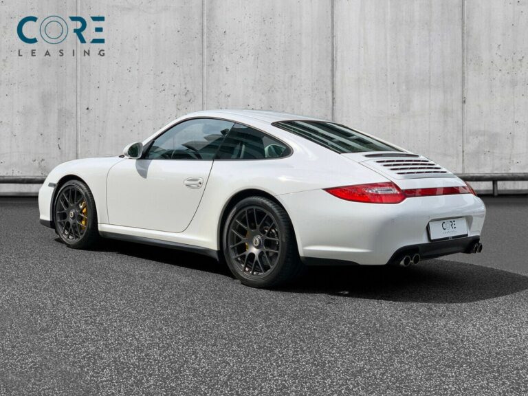 Hvidmetal Porsche 911 Carrera 4 GTS Coupé fra 2012 parkeret foran en betonmur. CORE Leasing A/S er eksperter i Porsche leasing.