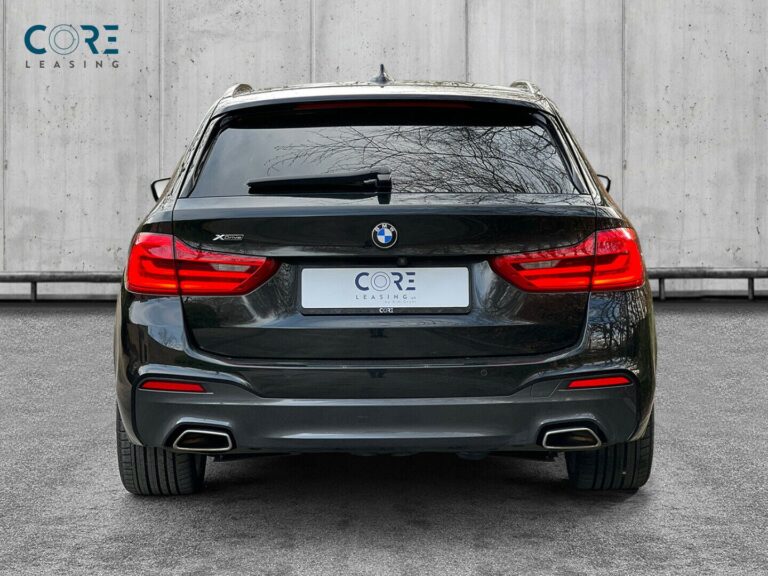 Sortmetal BMW 540d Touring M-Sport xDrive aut. fra 2018 parkeret foran en betonmur. CORE Leasing A/S er eksperter i BMW leasing.