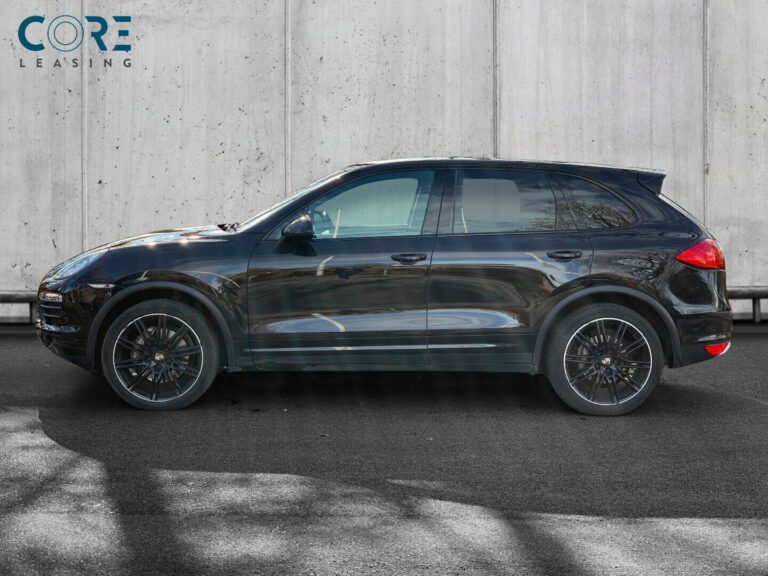 Sortmetal Porsche Cayenne S Tiptr. fra 2011 parkeret foran en betonmur. CORE Leasing A/S er eksperter i Porsche leasing.