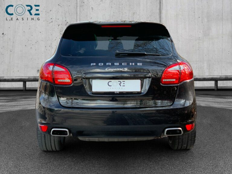 Sortmetal Porsche Cayenne S Tiptr. fra 2011 parkeret foran en betonmur. CORE Leasing A/S er eksperter i Porsche leasing.