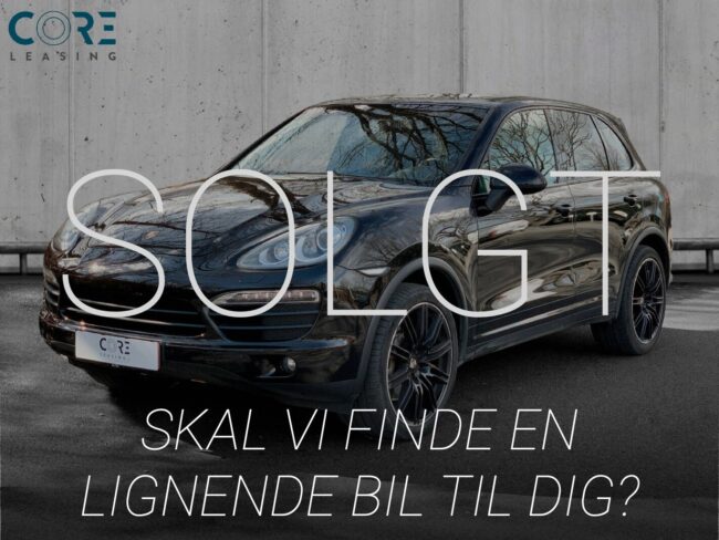 Sortmetal Porsche Cayenne S Tiptr. fra 2011 parkeret foran en betonmur. CORE Leasing A/S er eksperter i Porsche leasing.