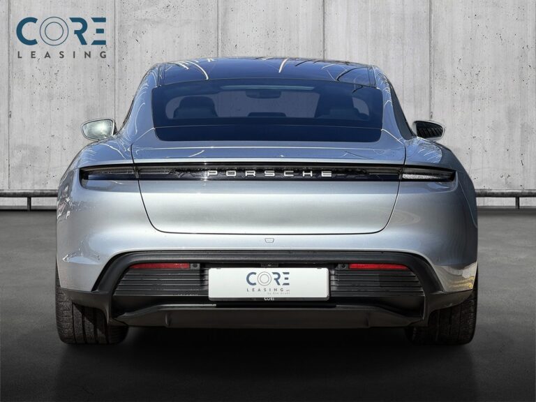 Sølvmetal Porsche Taycan 4S Performance+ fra 2021 parkeret foran en betonmur. CORE Leasing A/S er eksperter i Porsche leasing.