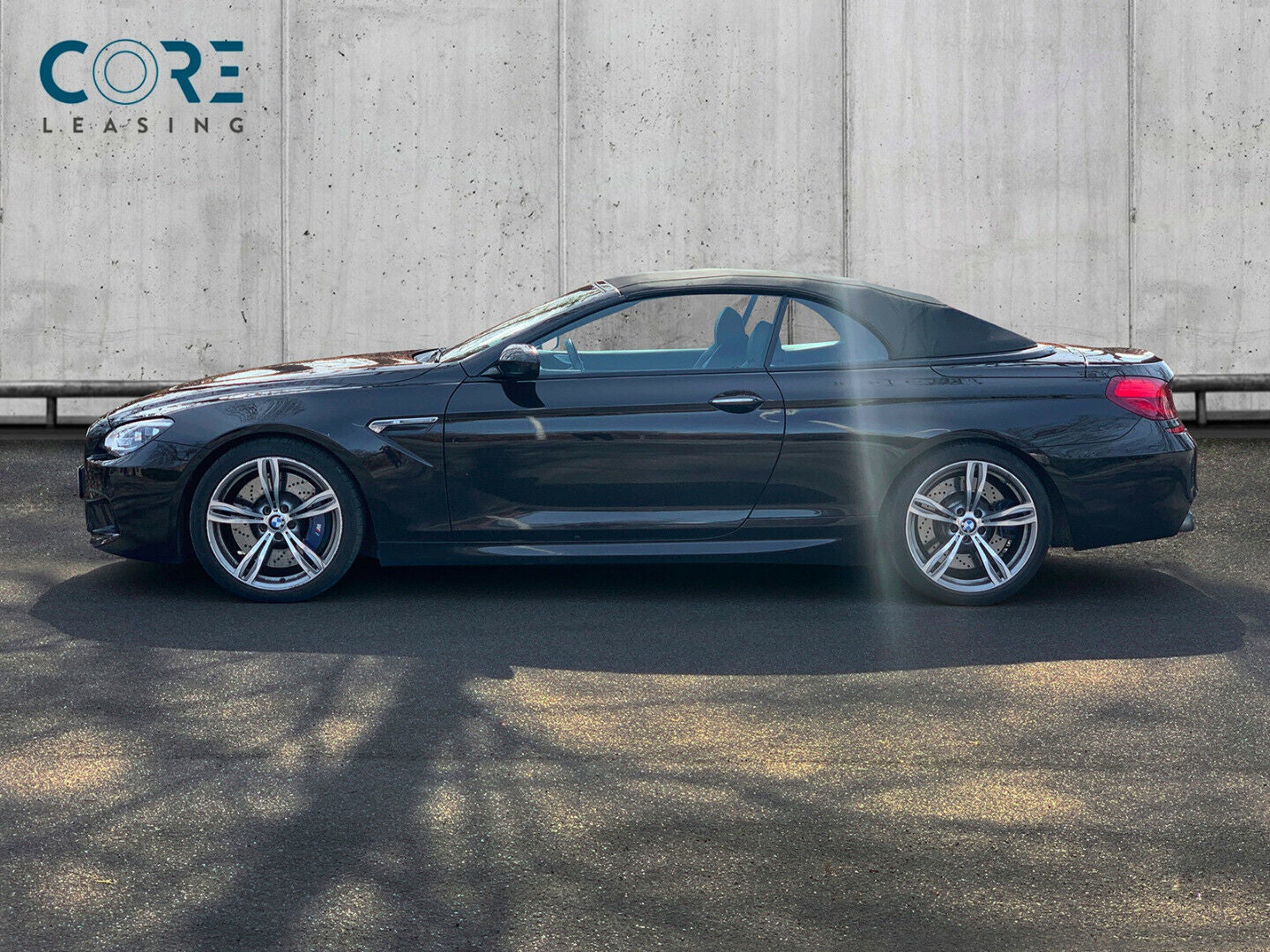 Sortmetal BMW M6 Cabriolet aut. fra 2013 parkeret foran en betonmur. CORE Leasing A/S er eksperter i BMW leasing.