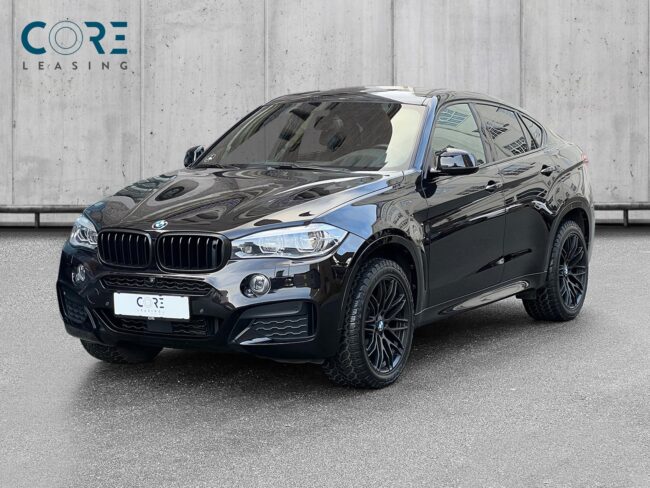 Sortmetal BMW X6 xDrive30d aut. fra 2016 parkeret foran en betonmur. CORE Leasing A/S er eksperter i BMW leasing.