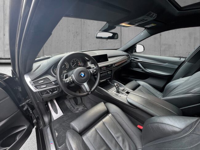 Sortmetal BMW X6 xDrive30d aut. fra 2016 parkeret foran en betonmur. CORE Leasing A/S er eksperter i BMW leasing.