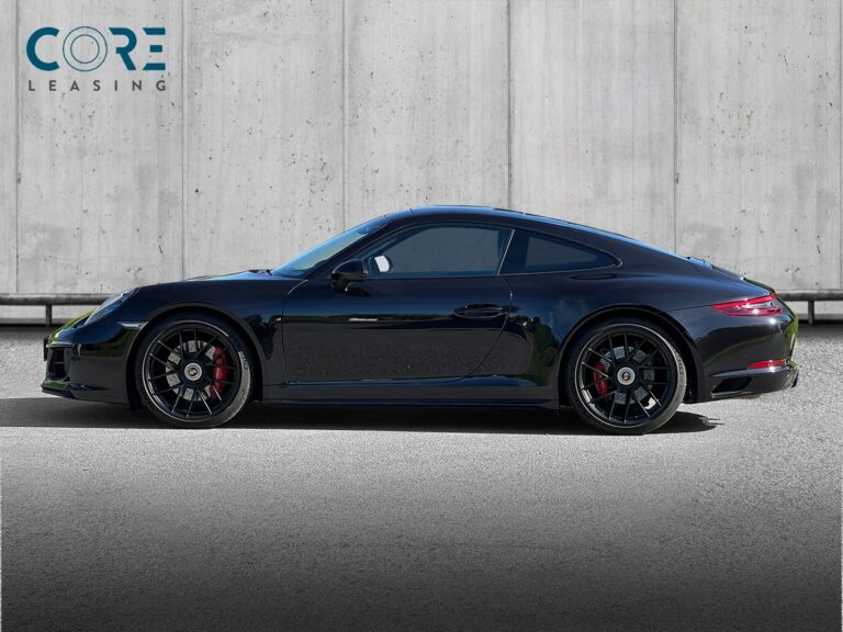 Sortmetal Porsche 911 Carrera 4 GTS Coupé PDK fra 2017 parkeret foran en betonmur. CORE Leasing A/S er eksperter i Porsche leasing.