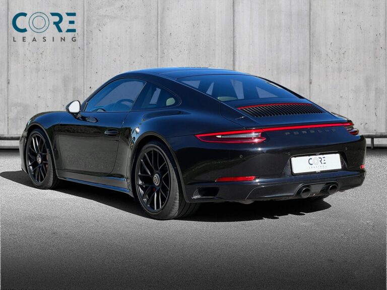 Sortmetal Porsche 911 Carrera 4 GTS Coupé PDK fra 2017 parkeret foran en betonmur. CORE Leasing A/S er eksperter i Porsche leasing.