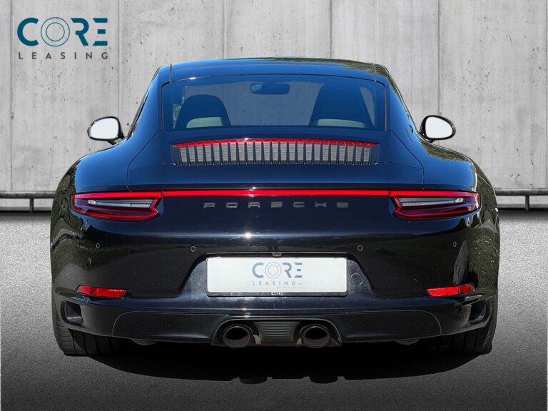 Sortmetal Porsche 911 Carrera 4 GTS Coupé PDK fra 2017 parkeret foran en betonmur. CORE Leasing A/S er eksperter i Porsche leasing.